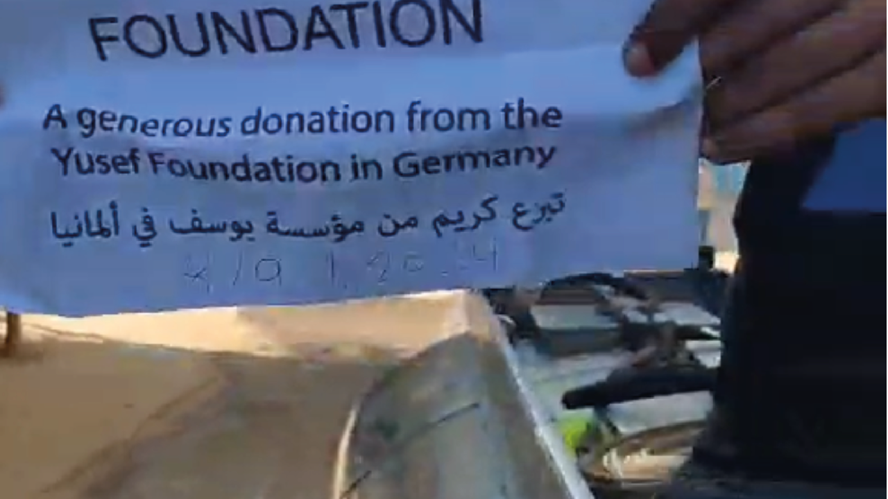 Freiwillige verteilen Wasser an bedürftige Menschen in Gaza-City.