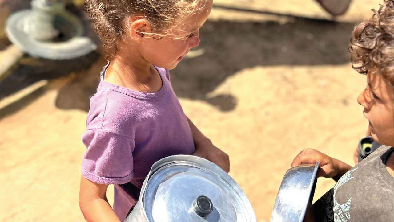 Freiwillige geben warme Suppe an bedürftige Menschen in einem Dorf bei Rafah aus.